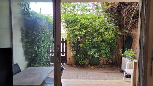 une porte ouverte menant à un jardin avec une clôture dans l'établissement Studio Les Lecques 100m de la plage, à Saint-Cyr-sur-Mer