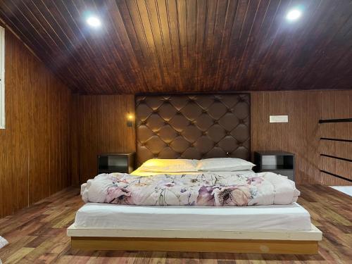a bedroom with a large bed with a wooden ceiling at Paaree Ghar in Gangtok