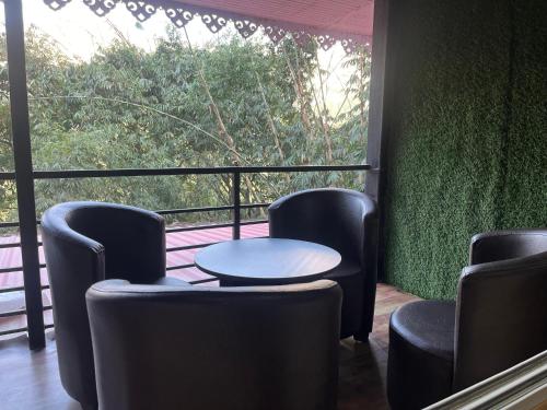 a room with chairs and a table and a window at Paaree Ghar in Gangtok