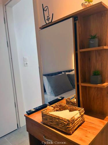 a desk with a mirror and a wicker basket at Cycladic Cocoon Mykonos Town in Megali Ammos