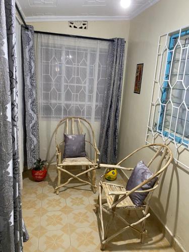 two chairs sitting in a room with a window at Matildah's Tranquil Haven in Siaya