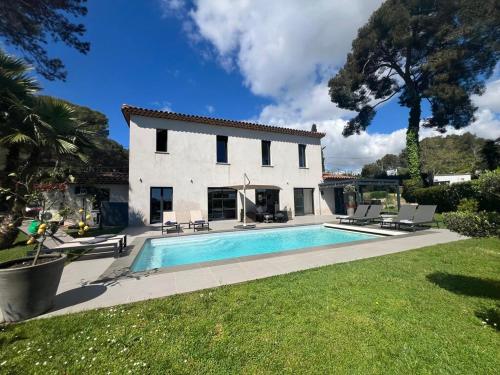 une maison avec une piscine devant dans l'établissement Villa Les Jasmins - Le Cannet-Vallauris - Modern with AC, ideal for fun and work, à Vallauris