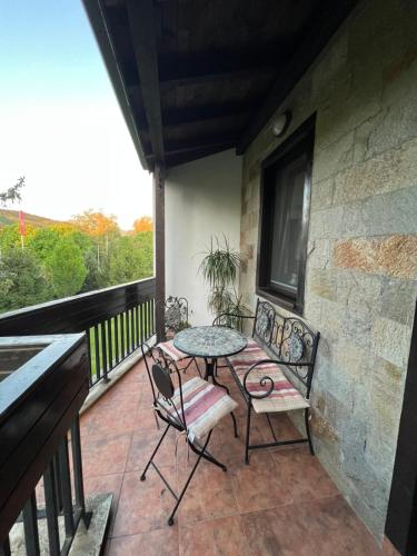 a patio with a table and chairs on a balcony at Pravets Lake Panorama Apartments in Pravets