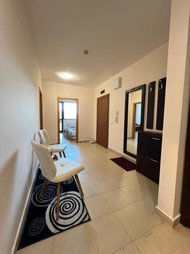 a living room with a white chair and a mirror at Pravets Lake Panorama Apartments in Pravets