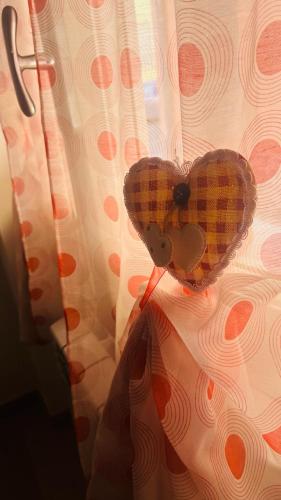 a person holding a heart attached to a curtain at Gevihome in Capua