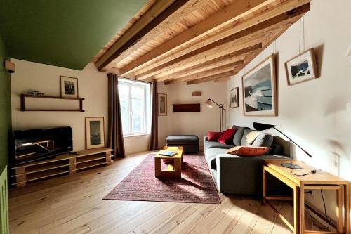 a living room with a couch and a table at La Maison Rouge sur le port à proximité de toutes commodités 2 personnes in Plérin
