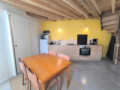 a kitchen with a wooden table and a dining room at La Maison Rouge sur le port à proximité de toutes commodités 2 personnes in Plérin