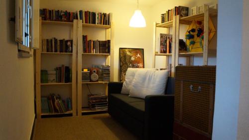 a living room with a couch and book shelves with books at Casa da Quelha in Chãs de Égua