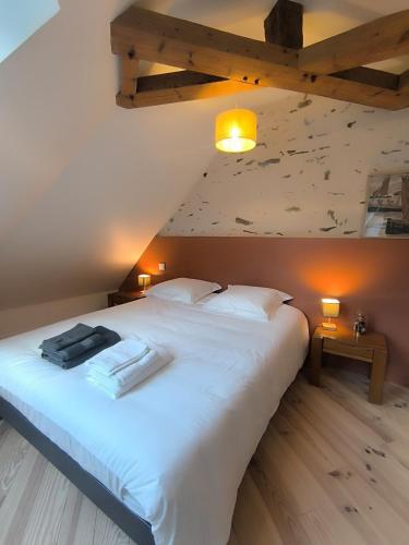 une chambre avec un grand lit blanc dans un grenier dans l'établissement La Maison Rouge sur le port à proximité de toutes commodités 2 personnes, à Plérin