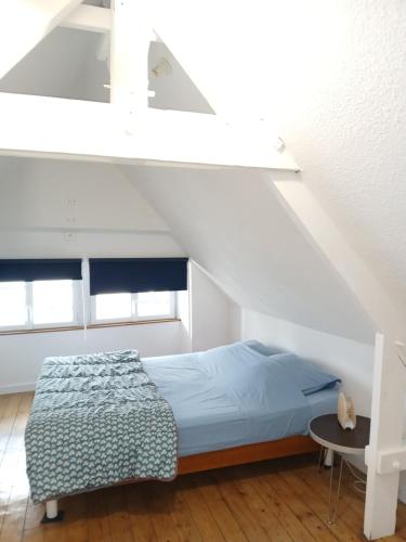une chambre avec un lit dans un grenier dans l'établissement Le Coucou Rennais, à Rennes