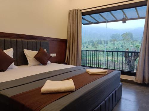 a bedroom with a bed with a large window at The Tree House in Vythiri