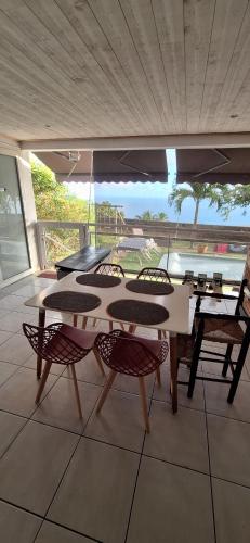 a room with tables and chairs and a large window at Location ST LEU CHEZ CARO in Étang