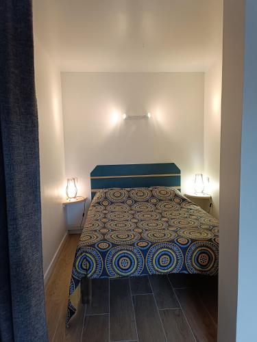 - une chambre avec un lit et deux lumières sur deux tables dans l'établissement le studio du Chat qui Pêche, à Gruissan