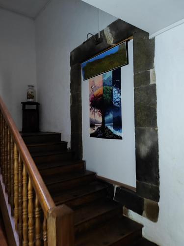 un escalier dans une maison avec une photo sur le mur dans l'établissement L'Auberge du pèlerin - ST JEAN PIED DE PORT, à Saint-Jean-Pied-de-Port