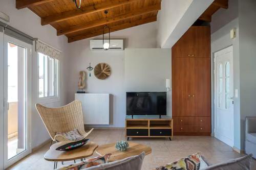 a living room with a couch and a tv at Irene Apartment in Néa Alikarnassós
