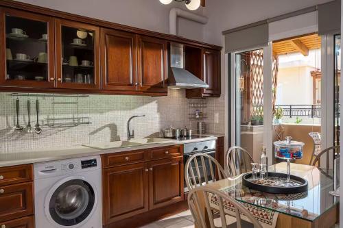 a kitchen with a table and a washing machine at Irene Apartment in Néa Alikarnassós