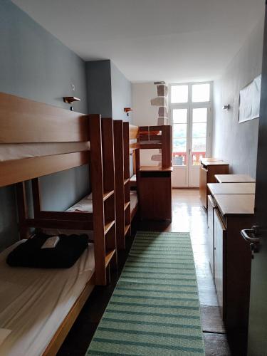 Cette chambre comprend des lits superposés et un tapis vert. dans l'établissement L'Auberge du pèlerin - ST JEAN PIED DE PORT, à Saint-Jean-Pied-de-Port