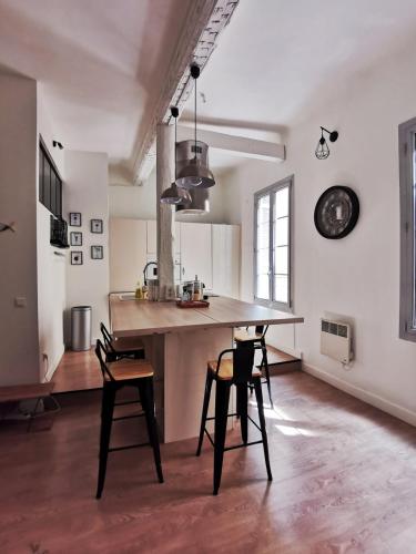 une cuisine avec une table et des chaises dans une pièce dans l'établissement L'Aixcapade, à Aix-en-Provence
