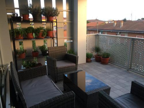 a balcony with chairs and tables and potted plants at Ai Santi B&B in Dossobuono