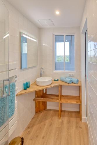une salle de bain blanche avec un lavabo et un miroir dans l'établissement Vue sur mer La Baule Palma, à La Baule
