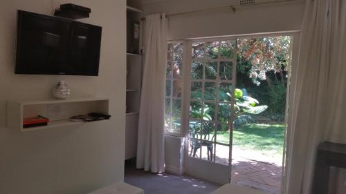 En TV eller et underholdningssystem på Rosebank Lodge Guesthouse by Claires