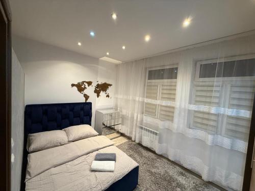 a bedroom with a blue bed and a window at Apartament Ząbki in Ząbki