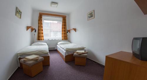 um quarto de hotel com duas camas e uma televisão em Sportovní Centrum Semily em Semily