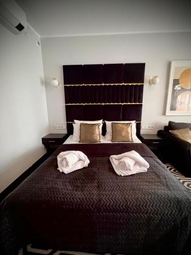 a bedroom with a large bed with two white pillows at Apartament Solny Resort A032 z klimatyzacją i ogrodem in Kołobrzeg