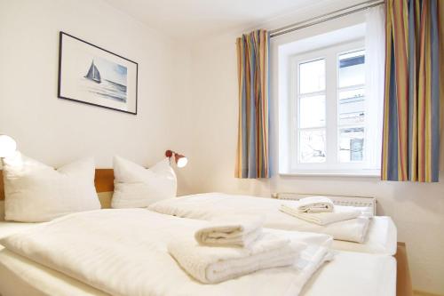 Un dormitorio con dos camas con toallas encima. en Vineta-App-02, en Heringsdorf