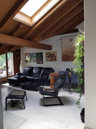 a living room with a black couch and a table at Lauterbrunnen Staubbach Amazing Waterfall View in Lauterbrunnen