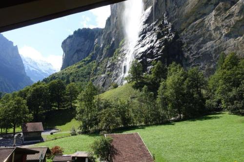 a view of a waterfall in a mountain at Lauterbrunnen Staubbach Amazing Waterfall View in Lauterbrunnen