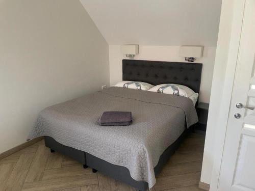 Dormitorio pequeño con cama con manta en Palanga Cozy Studio, en Palanga