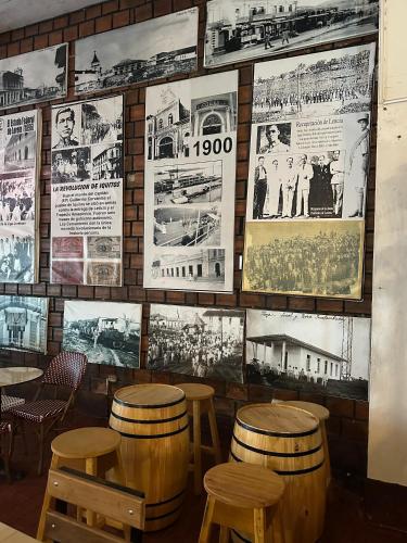 a restaurant with wooden stools and posters on the wall at La Posada del Cauchero Hotel & Suites in Iquitos