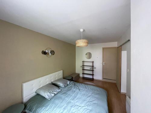 - une chambre avec un lit à tête blanche dans l'établissement Appartement moderne & pittoresques, à Caen