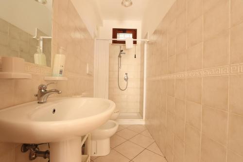a white bathroom with a sink and a toilet at ModernShore - Oltremare in Tortoreto Lido