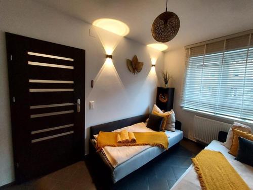 a bedroom with a bed with a yellow blanket at AuroraBoguszow in Boguszów-Gorce