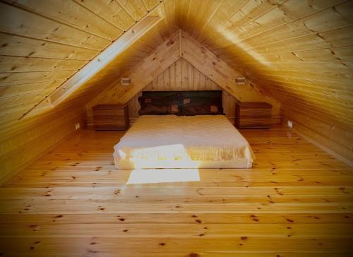 a bedroom with a bed in a wooden attic at Dom na Mazurach dla kilku rodzin! Jedyny taki! HACIENDA in Radzieje
