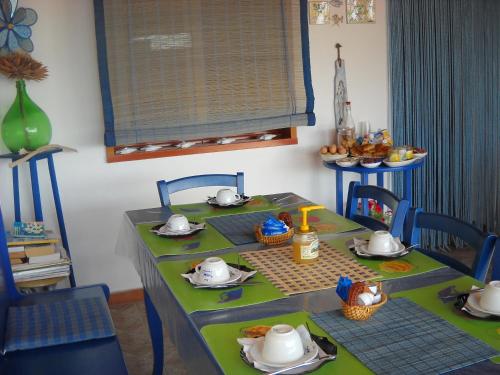 una mesa con mantel verde y sillas azules en Il Pescatore, en Marinella di Selinunte