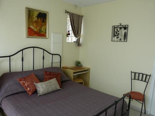 une chambre avec un lit avec une chaise et une fenêtre dans l'établissement Appartement Elody - Villa Cocooning, à Houilles