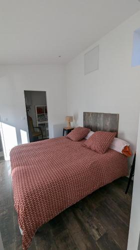 une chambre avec un lit avec une couette rouge dans l'établissement Appartement avec terrasse et balcon, à Bouzel