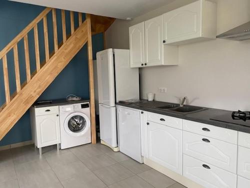 une cuisine avec un lave-linge et un escalier dans l'établissement Domaine d'Annégré, à Brem-sur-Mer