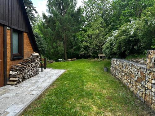 a backyard with a stone wall next to a house at Hájská chata in Teplice