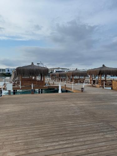 a boardwalk with straw umbrellas and a pier at Four Seasons Life - Luxury Beach Resort - Apartments with 2 Bedrooms in Iskele