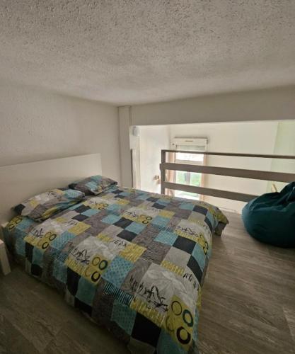 une chambre avec un lit avec une couette dessus dans l'établissement Résidence des Jasmins, à Metz