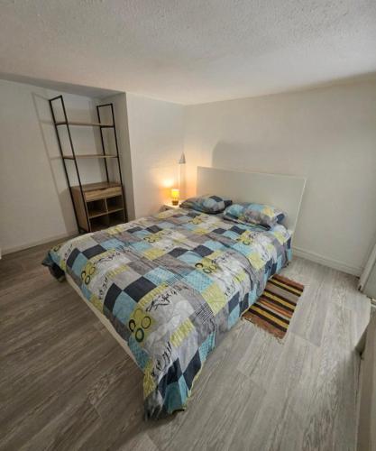 une chambre avec un lit avec une couette dessus dans l'établissement Résidence des Jasmins, à Metz