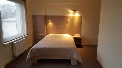 Schlafzimmer mit einem Bett und einem Fenster in der Unterkunft Hotel Gulbene in Gulbene