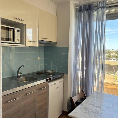 une cuisine avec un évier, une table et une fenêtre dans l'établissement Studio Héliopolis AB 242 - 4 personnes, au Cap d'Agde
