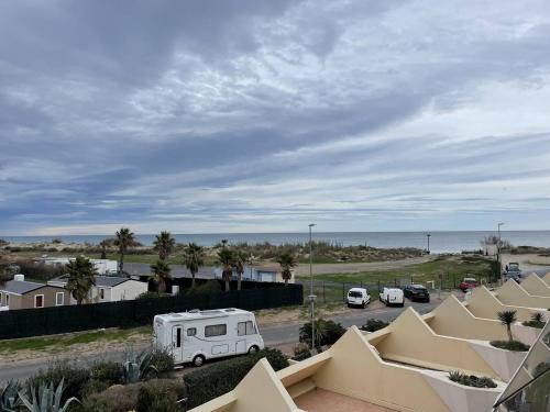 un camping-car garé sur un parking à côté de l'océan dans l'établissement Studio Héliopolis AB 310 - 3 personnes, au Cap d'Agde