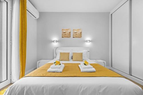 ein weißes Schlafzimmer mit einem großen Bett und zwei Handtüchern in der Unterkunft River Side in Senhora do Rosário