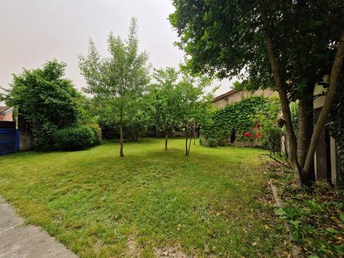 une cour avec des arbres et une maison dans l'établissement Gîte de las Randoletas, à Dreuilhe